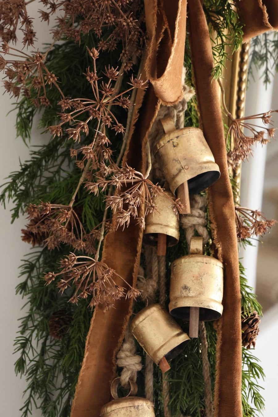 festive foliage with large brass cowbells on a garland 