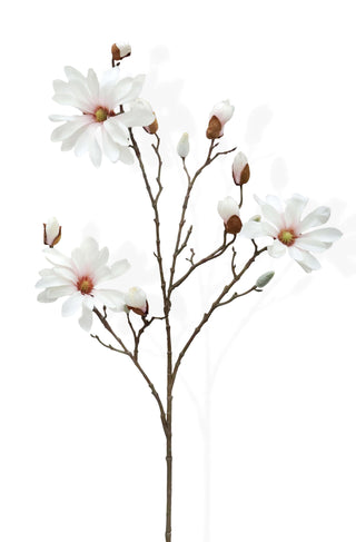 Artificial magnolia branch with pale pink flowers on a white background
