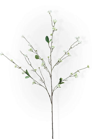 Artificial blossom branch with leaves and small flowers on a white background