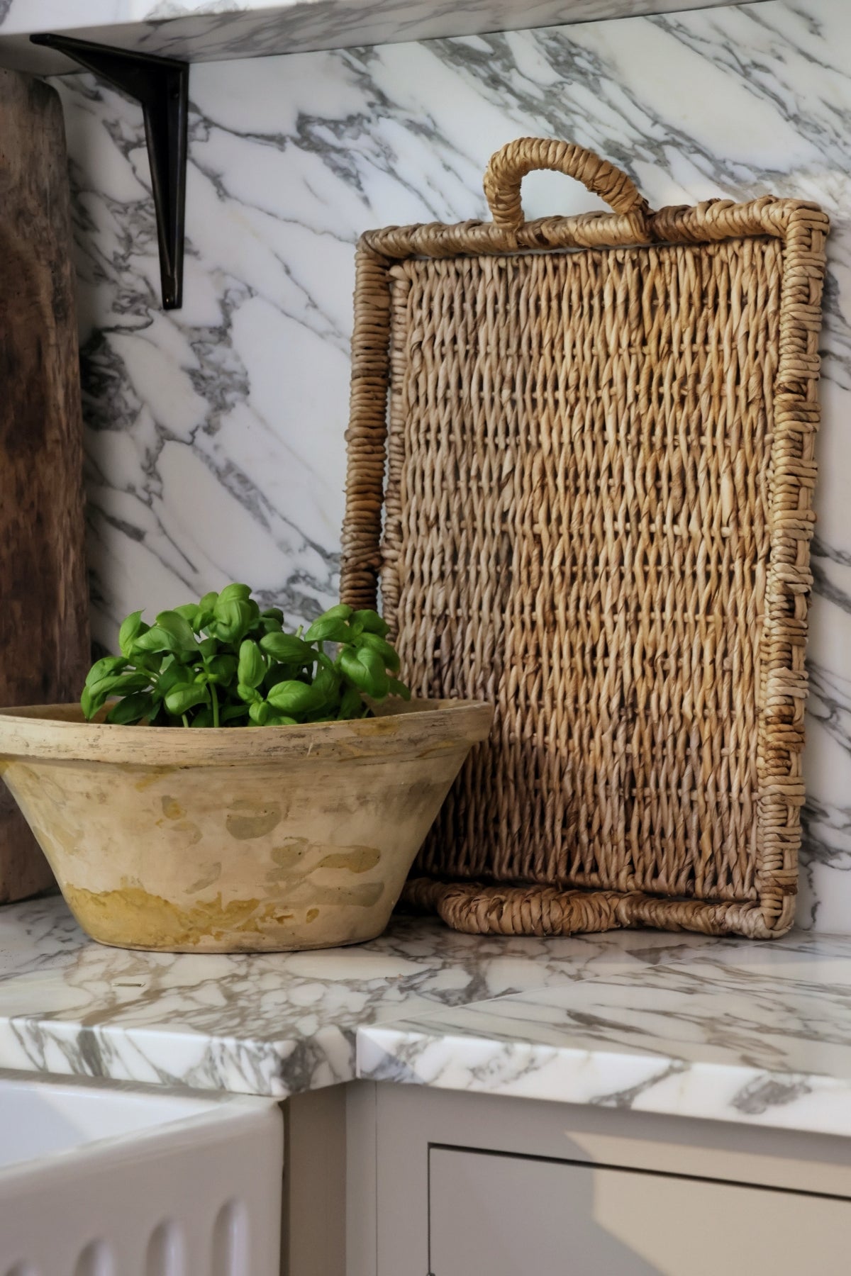 Rectangular banana bark tray standing up against marble kitchen backplash 