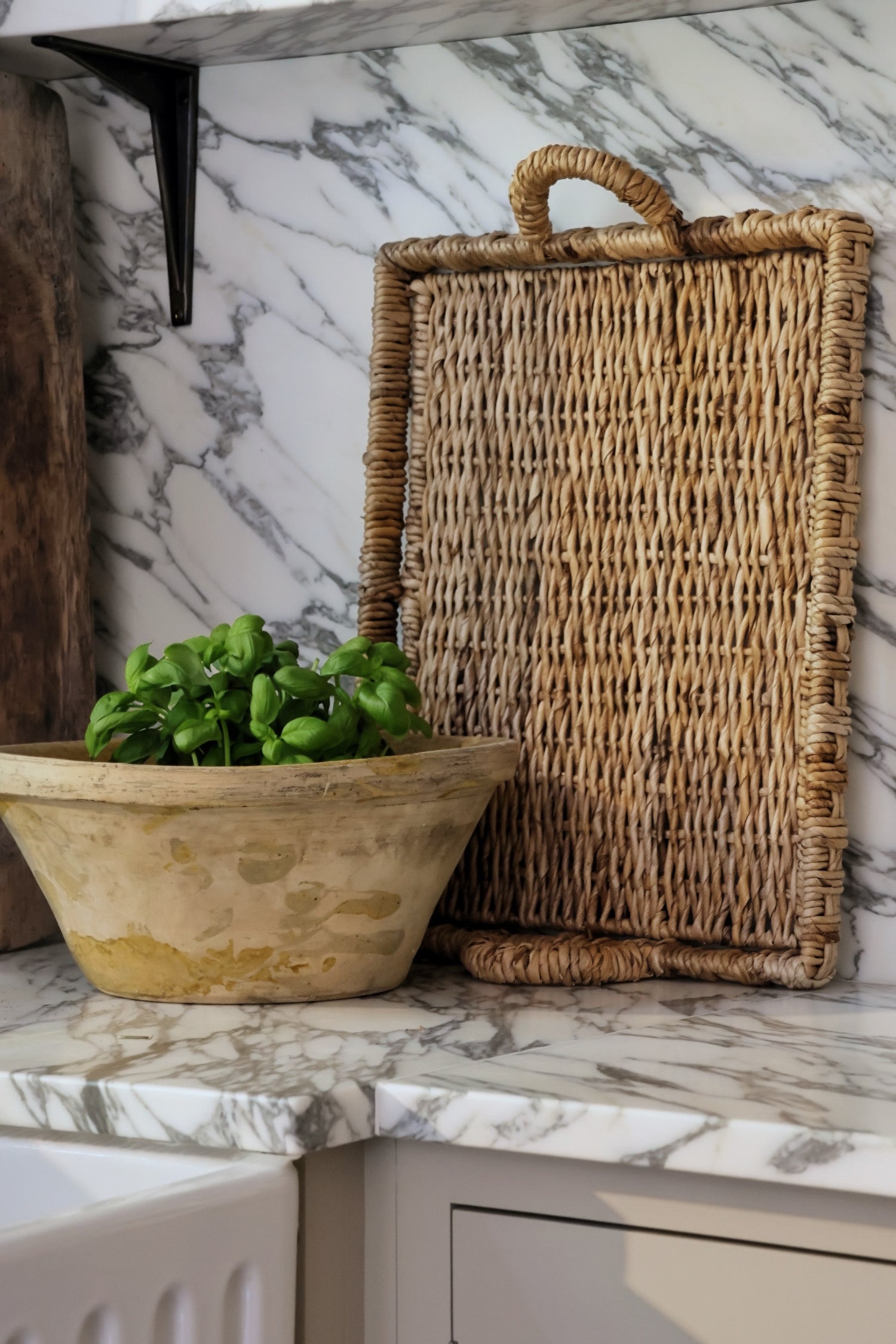 Rectangular banana bark tray standing up against marble kitchen backplash 