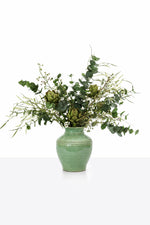 Large artificial Artichoke Arrangement with eucalyptus, artichokes and small white flowers in a green ceramic tapered vase on a white background 