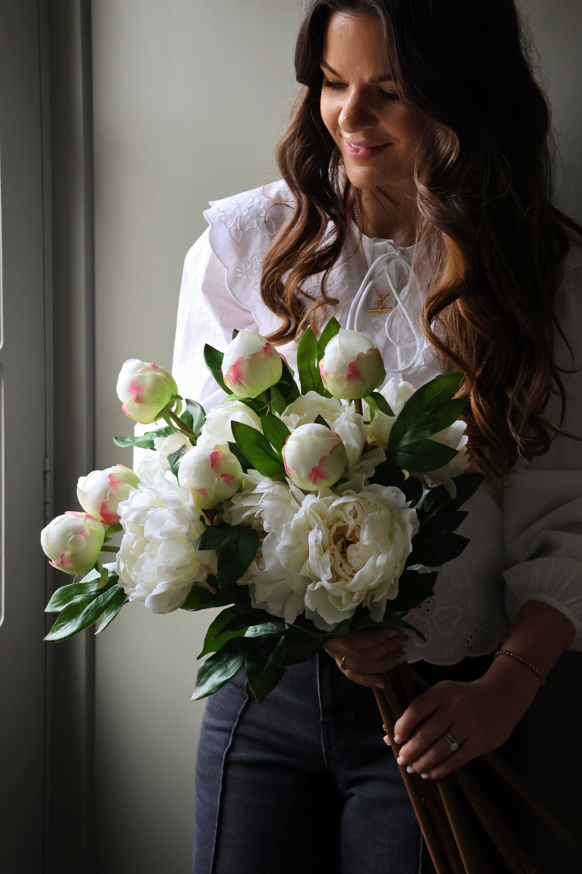 lady holding a bunch of artificial white peonies 
