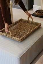 Large coffee table styling woven tray on an ottoman in lounge setting 