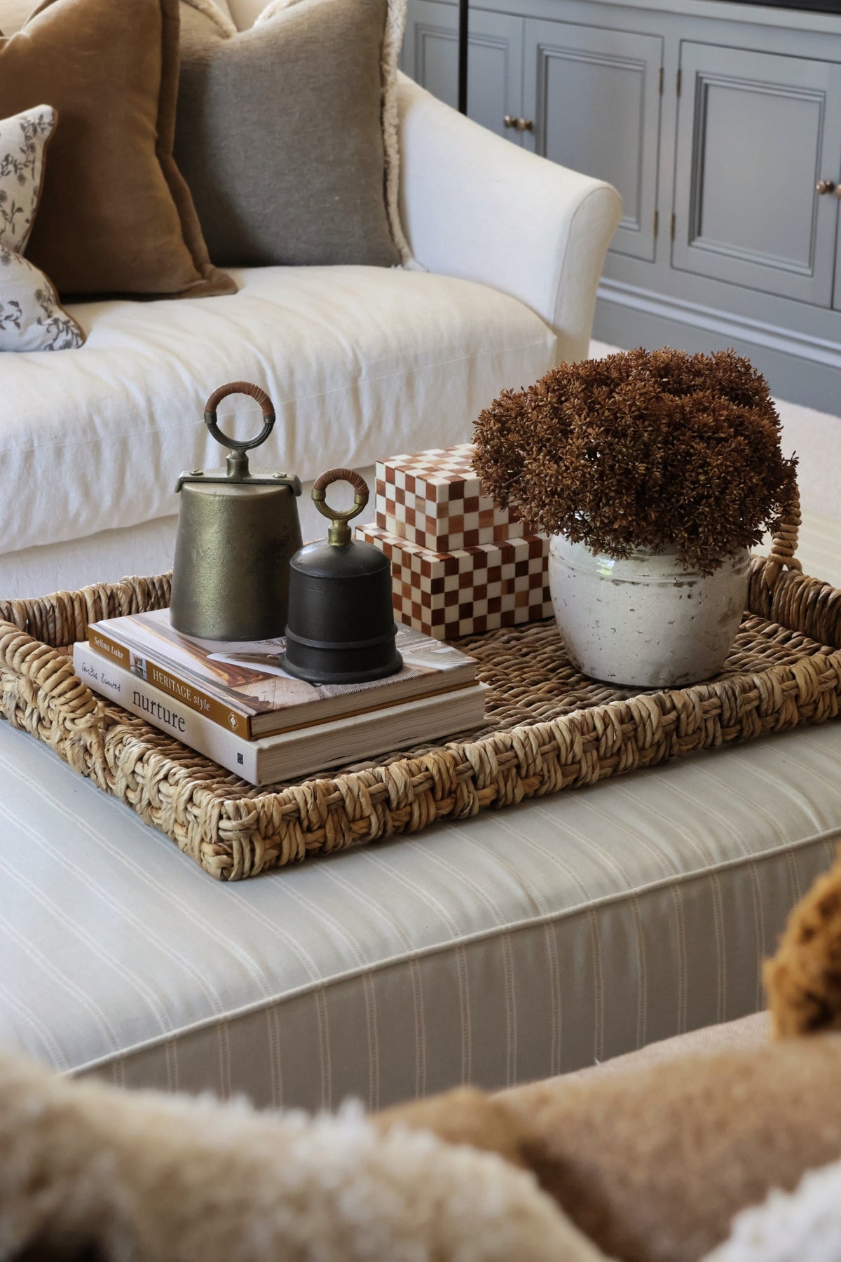 A styled ottomon with woven banana bark trayand decorative items 