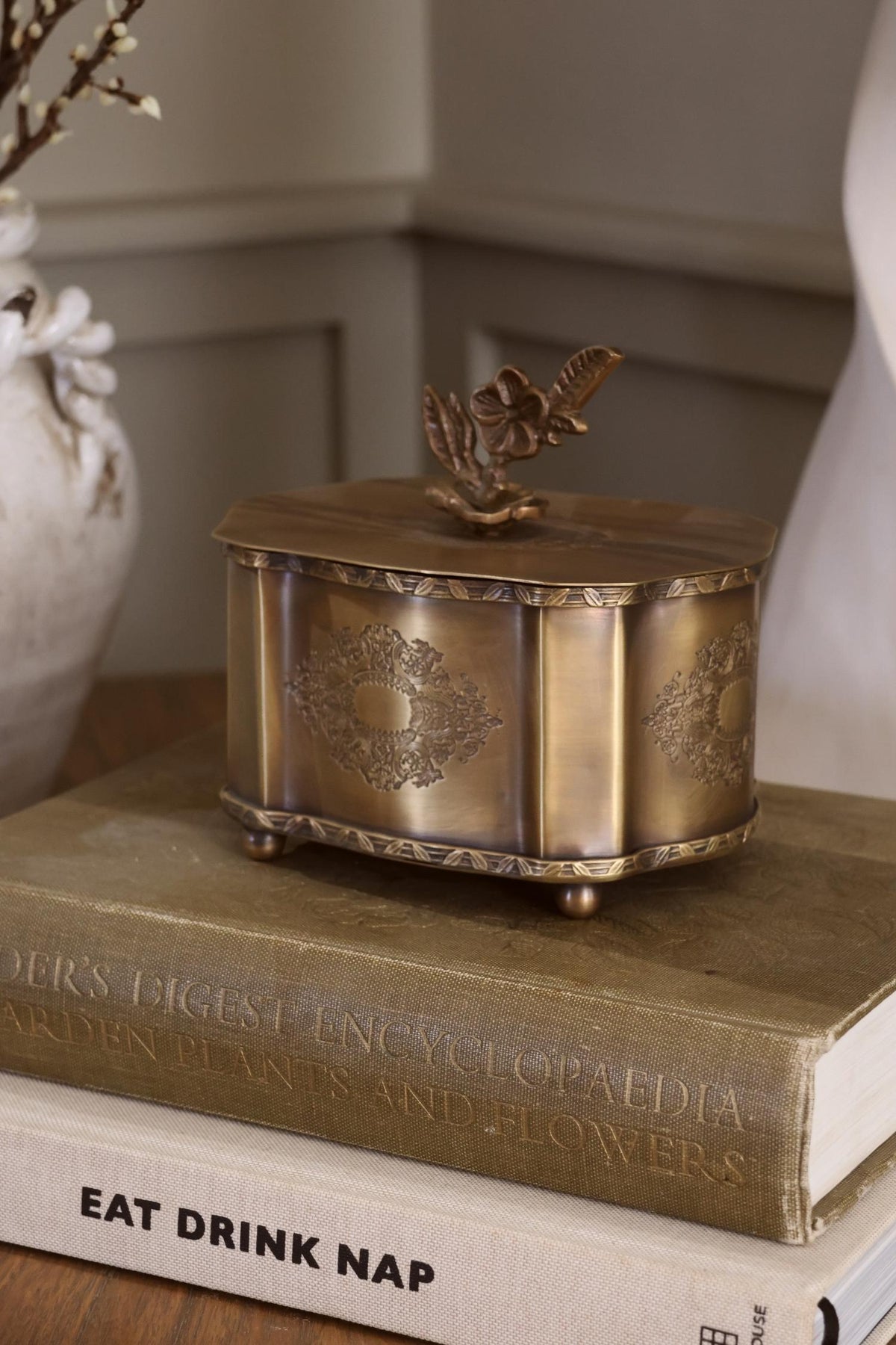 Antique brass hengrave box on a stack of books with blurred background 