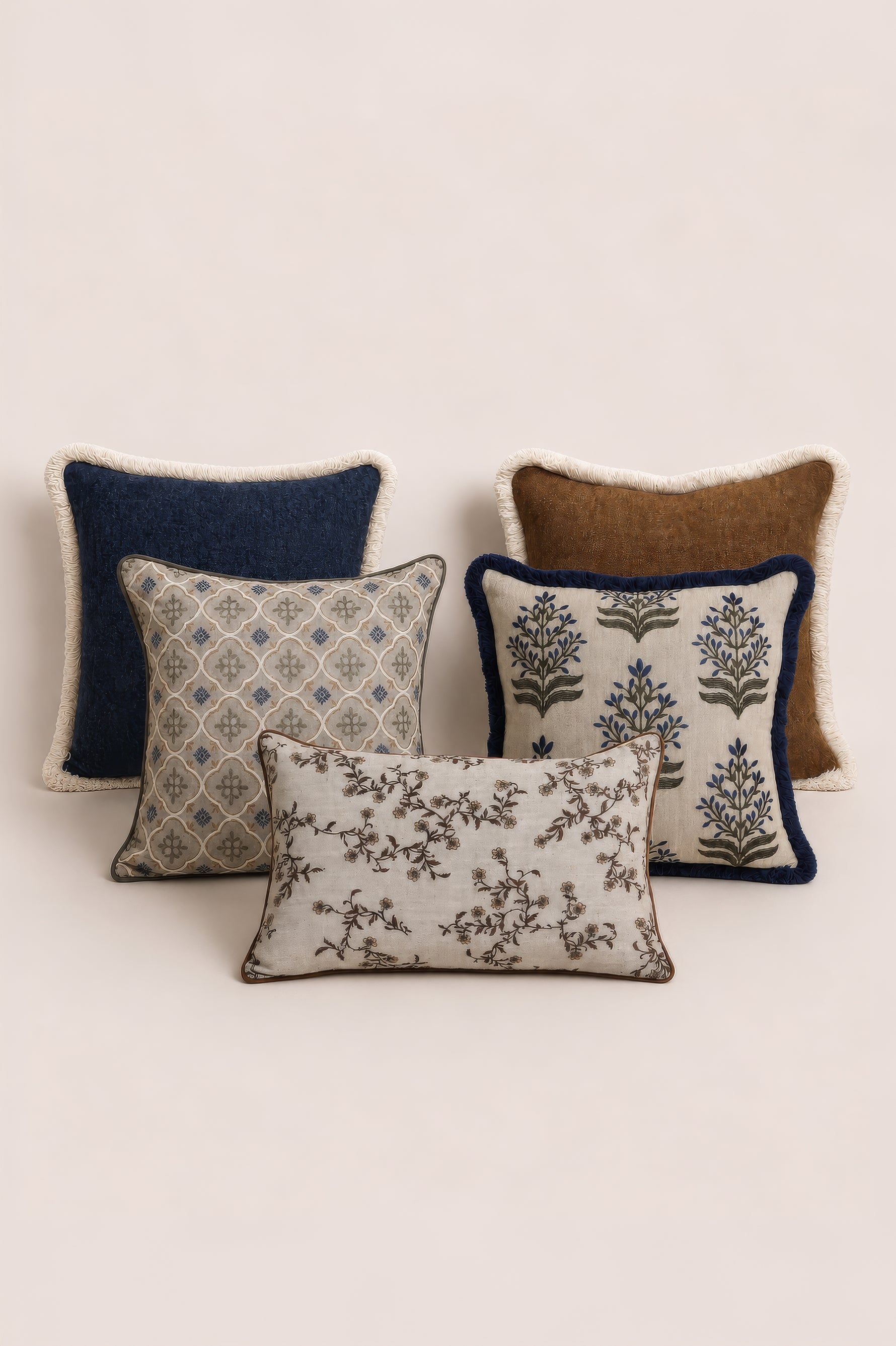 Set of four decorative cushions with various patterns and textures on a light background