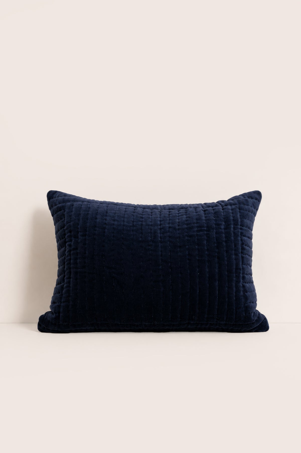 Navy blue textured pillow on a beige background