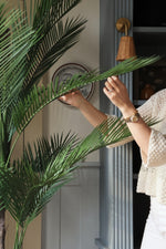 Faux palm tree 180cm leaves being arranged by ladies hands 