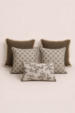 Four decorative cushions with different patterns on a beige background