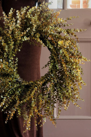 Green and yellow floral wreath on a door