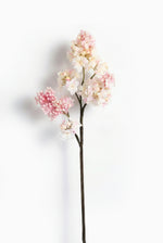 Artificial lilac flower branch with pink and white blossoms on a white background