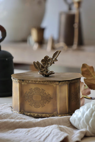 Decorative brass box with intricate design on a textured surface