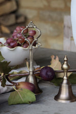 Decorative bronze bell with grapes and leaves on a stone surface