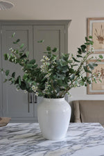 white ceramic Lavenham Vase on marble worktop with artificial green eucalyptus and waxflower stems