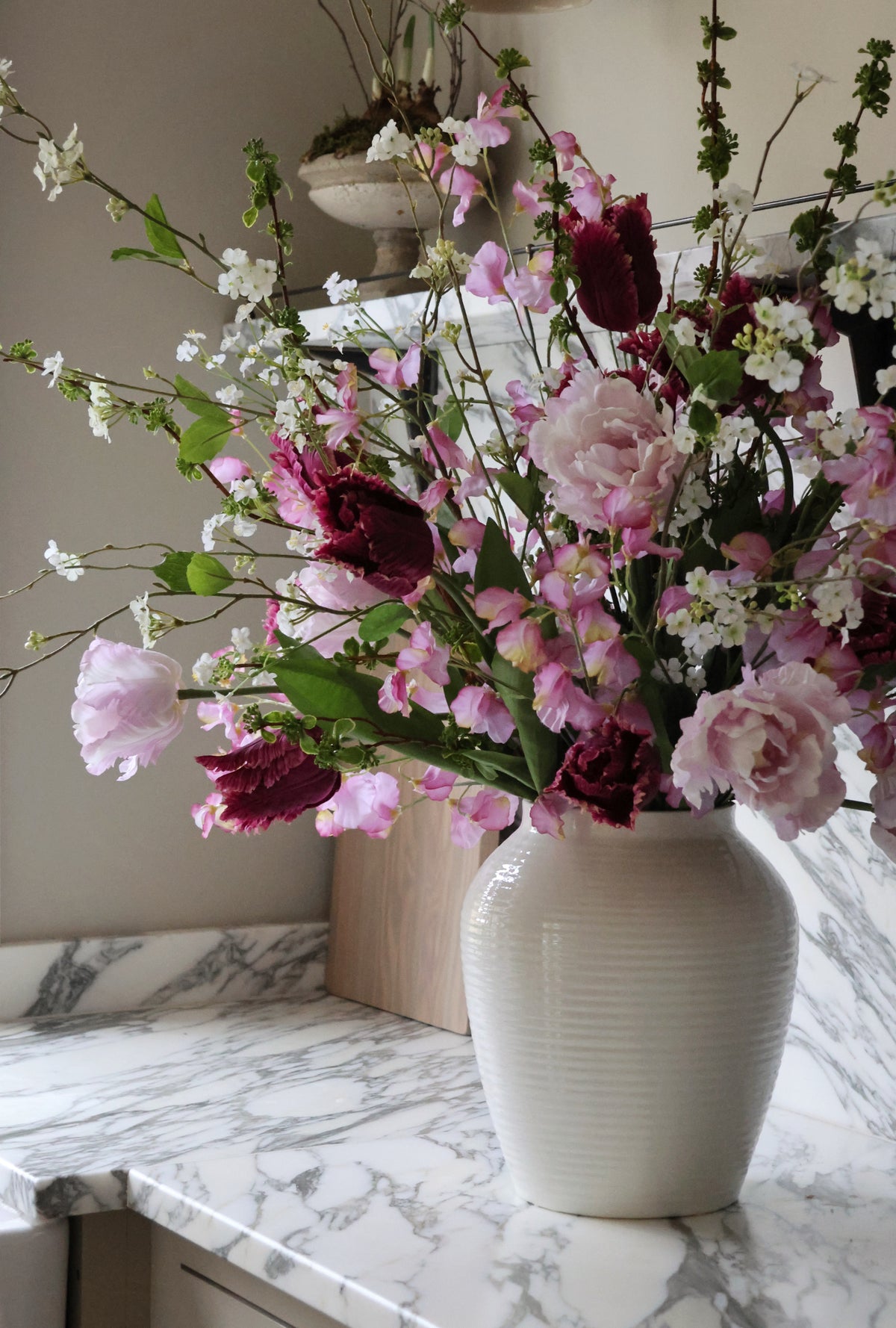 Vase of flowers on a marble countertop with a neutral background