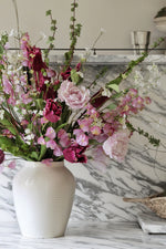 Floral arrangement in a white vase on a marble surface