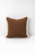 Decorative pillow with weave fringe on a white background