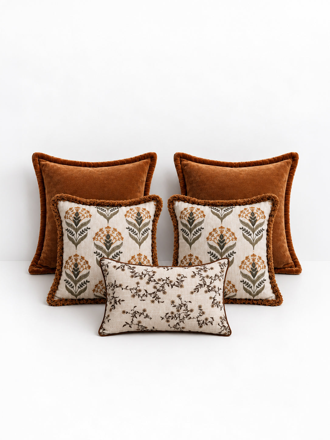 A set of ochre decorative cushions on a white background