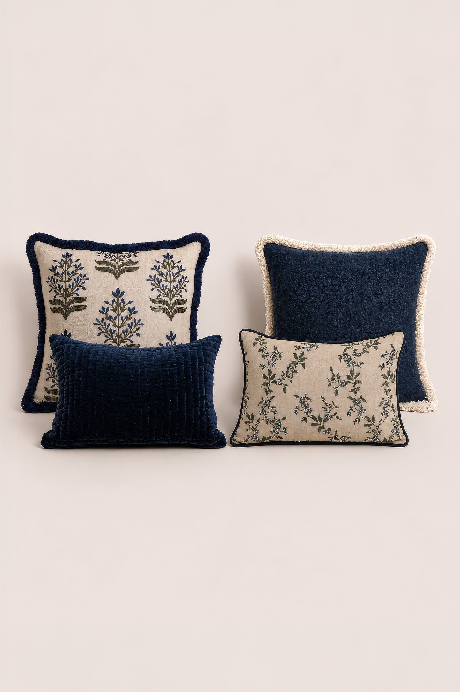 Four decorative cushions with floral patterns on a light beige background