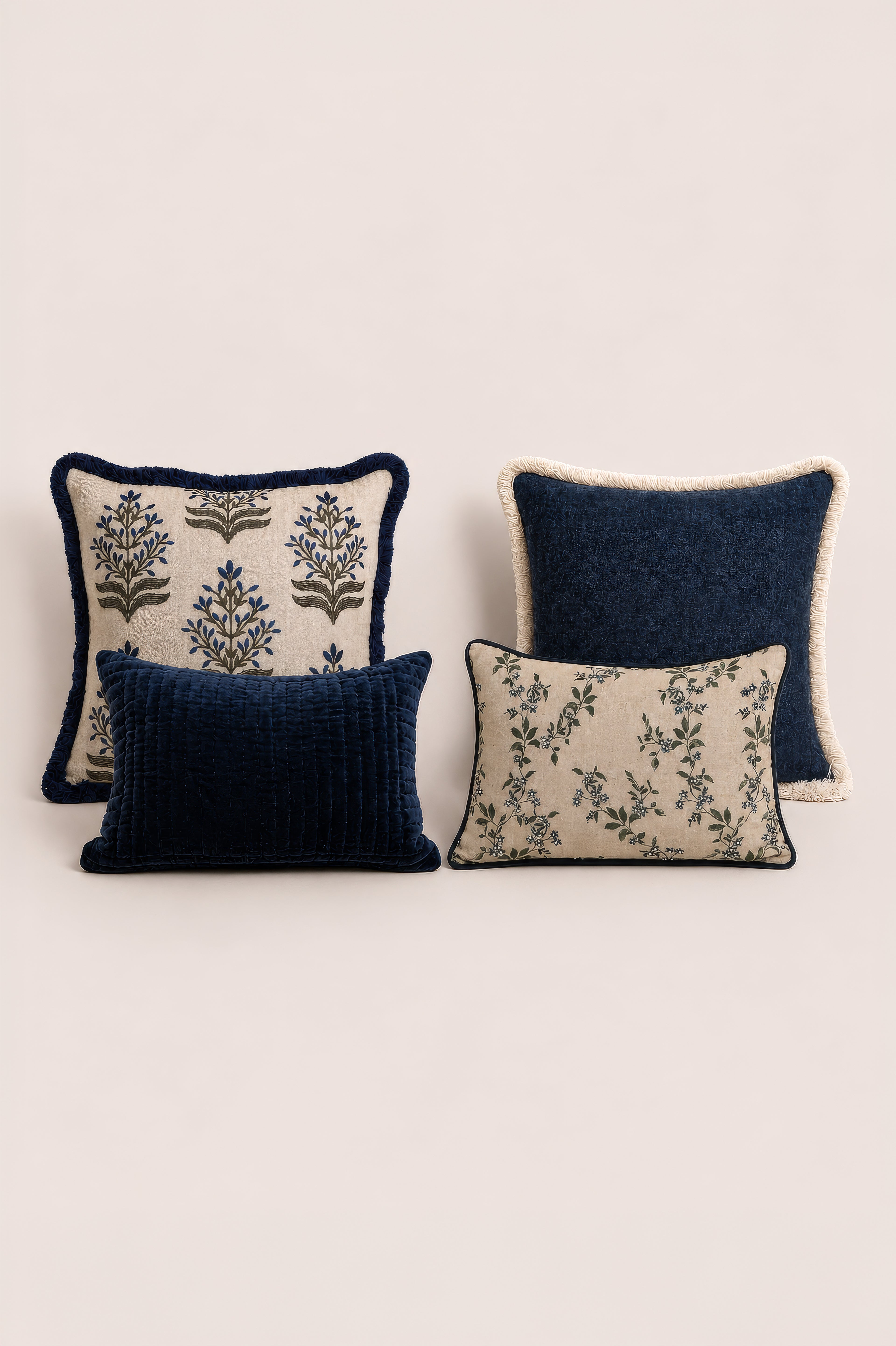 Four decorative cushions with floral patterns on a light beige background