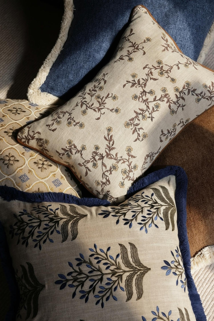 Decorative cushions with floral patterns on a textured surface