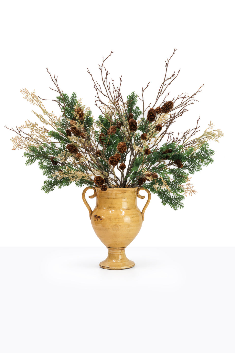 Artificial Christmas Winter Foliage Arrangement in a ceramic urn on white background
