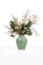 Artificial Christmas Winter Foliage Arrangement in a ceramic urn on white background