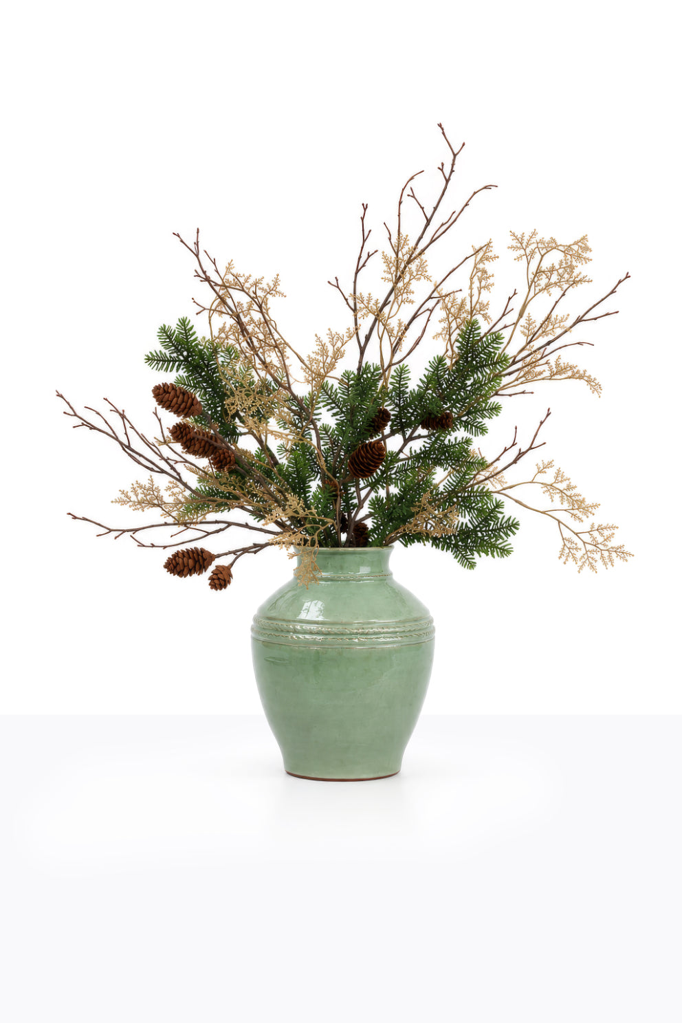 Artificial Christmas Winter Foliage Arrangement in a ceramic urn on white background