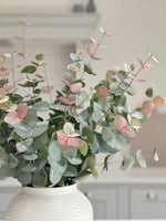 pink tipped eucalyptus stems in white vase
