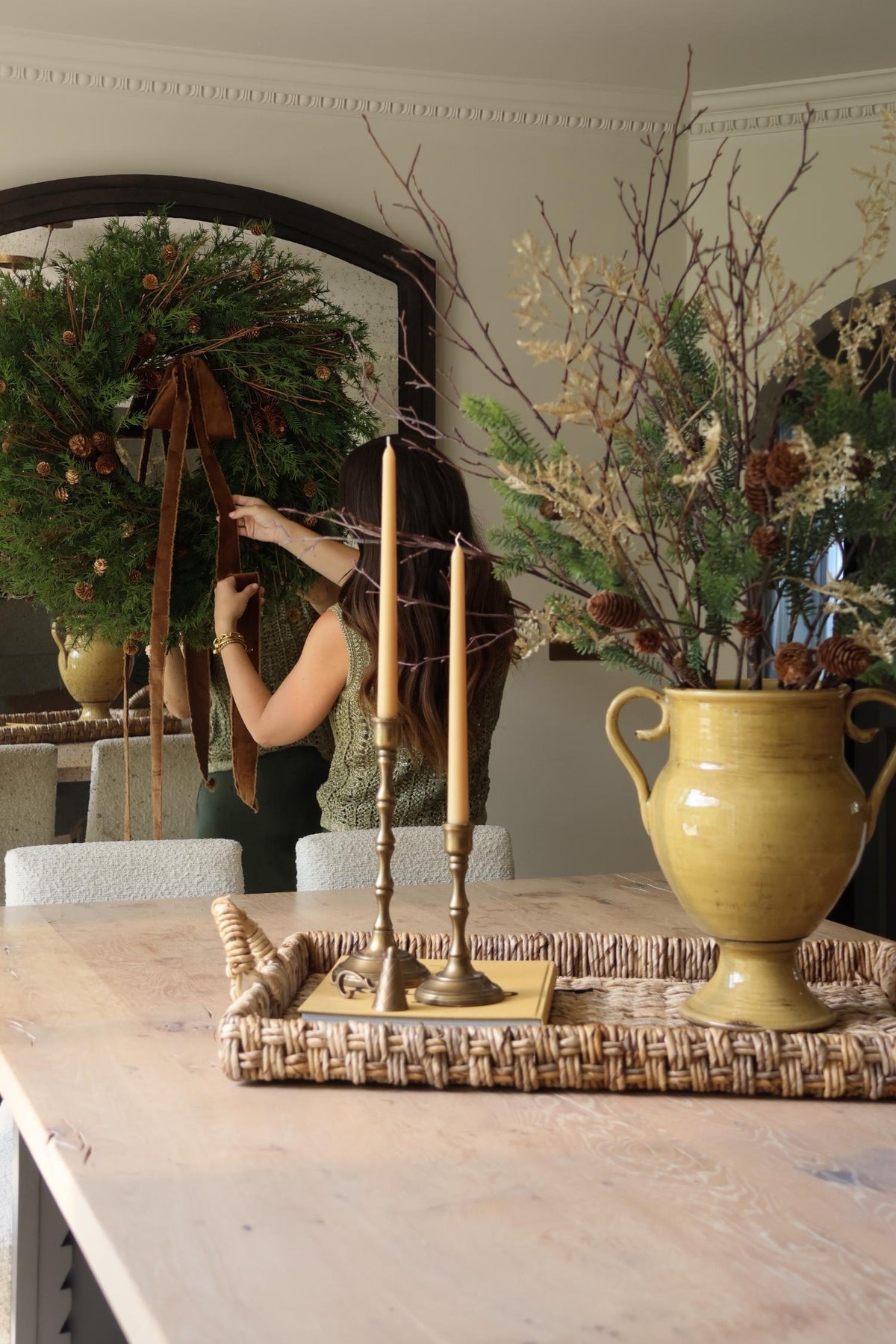 gestive decor kitchen island scene with large wreath in background and faux arrangement in the front on a woven tray 