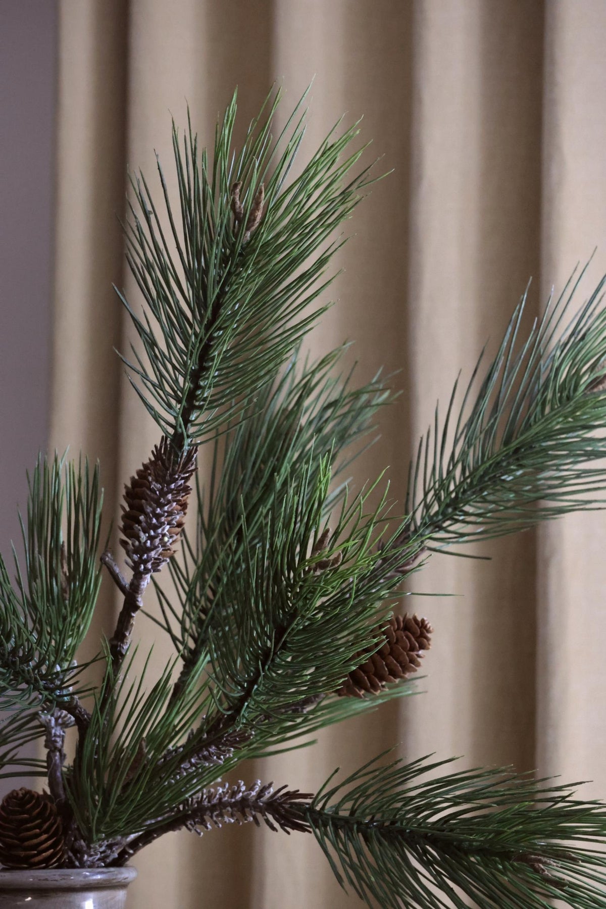 close up of artificial green pine branches against a blurred background