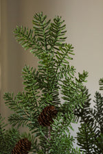 close up of artificial spruce branch on plain beige background 