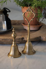 two decorative brass bells on a marble kitchen surface 