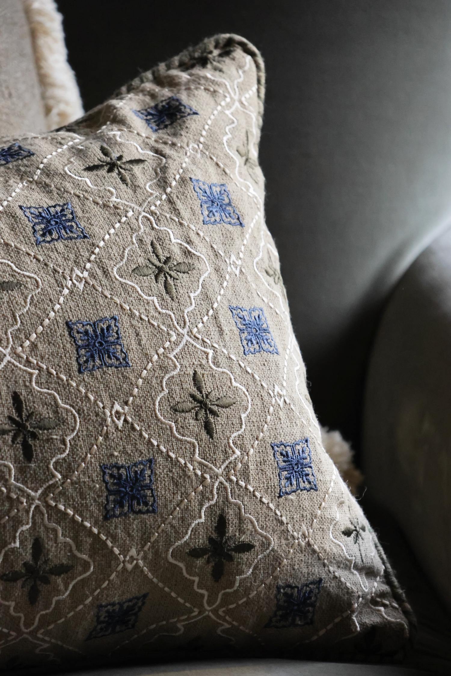 Decorative cushion with intricate patterns on a neutral background