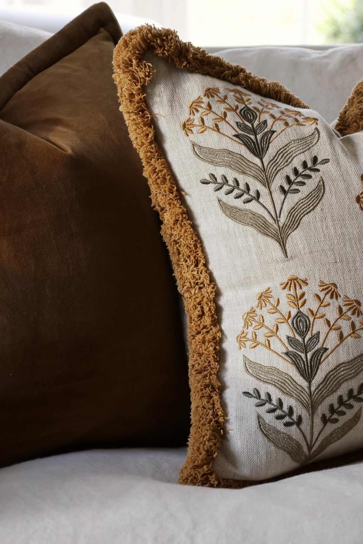 Decorative cushion with floral embroidery on a couch