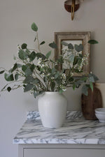 eucalyptus populus with waxflower in white vase on marble kitchen surface