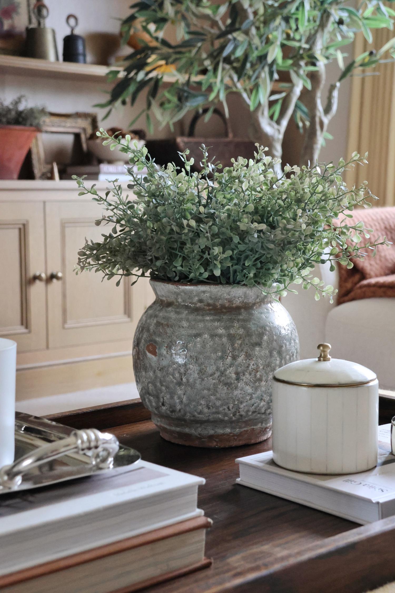 Decorative Henley vase with faux green eucalyptus bush on a coffee table in a home setting