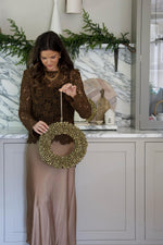 women holding a large bell wreath in kitchen 