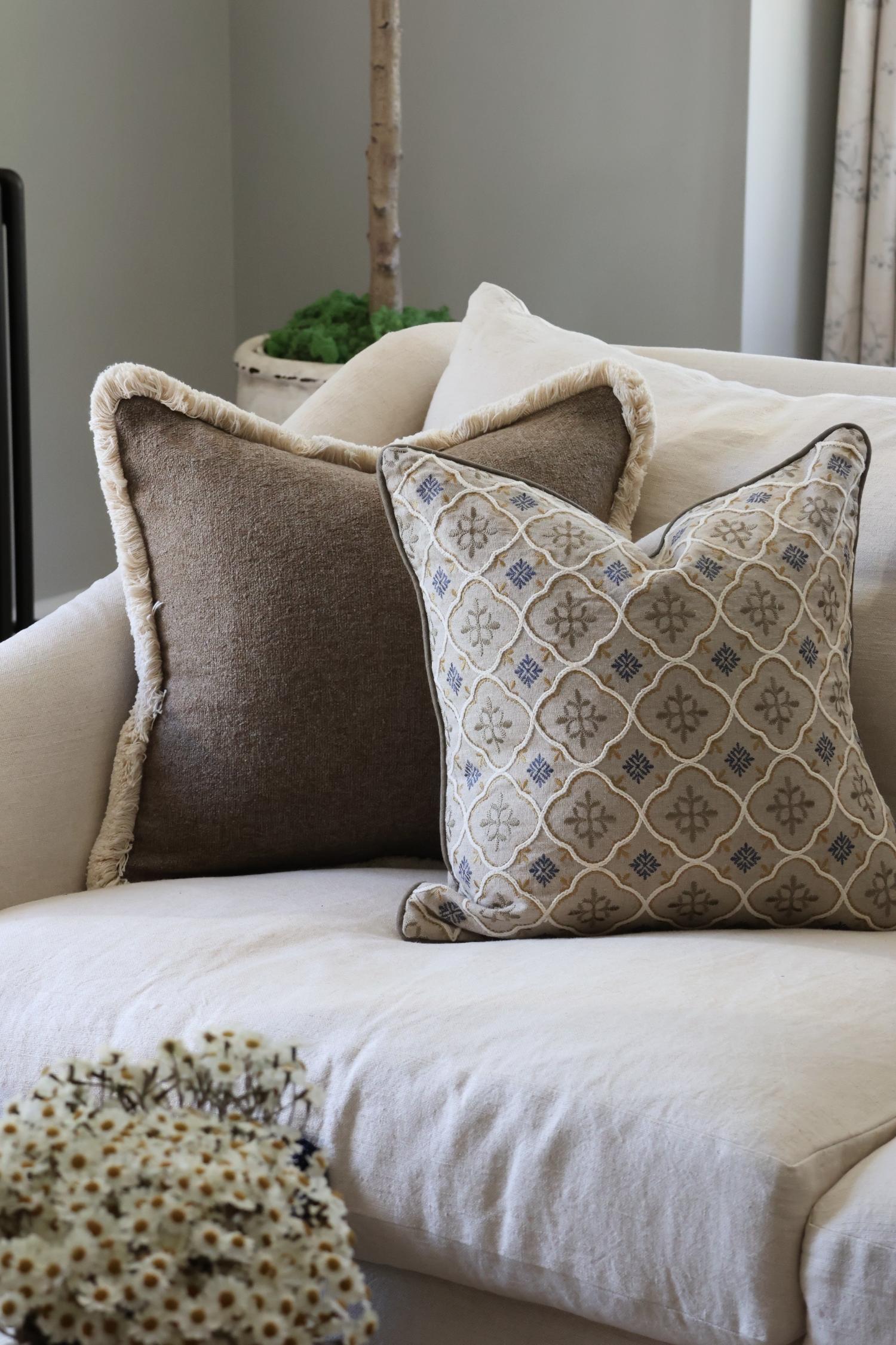 Decorative cushions on a beige sofa with a neutral background