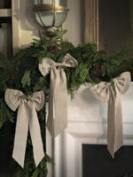 Decorative faux Christmas garland with ribbons on a fireplace mantel.