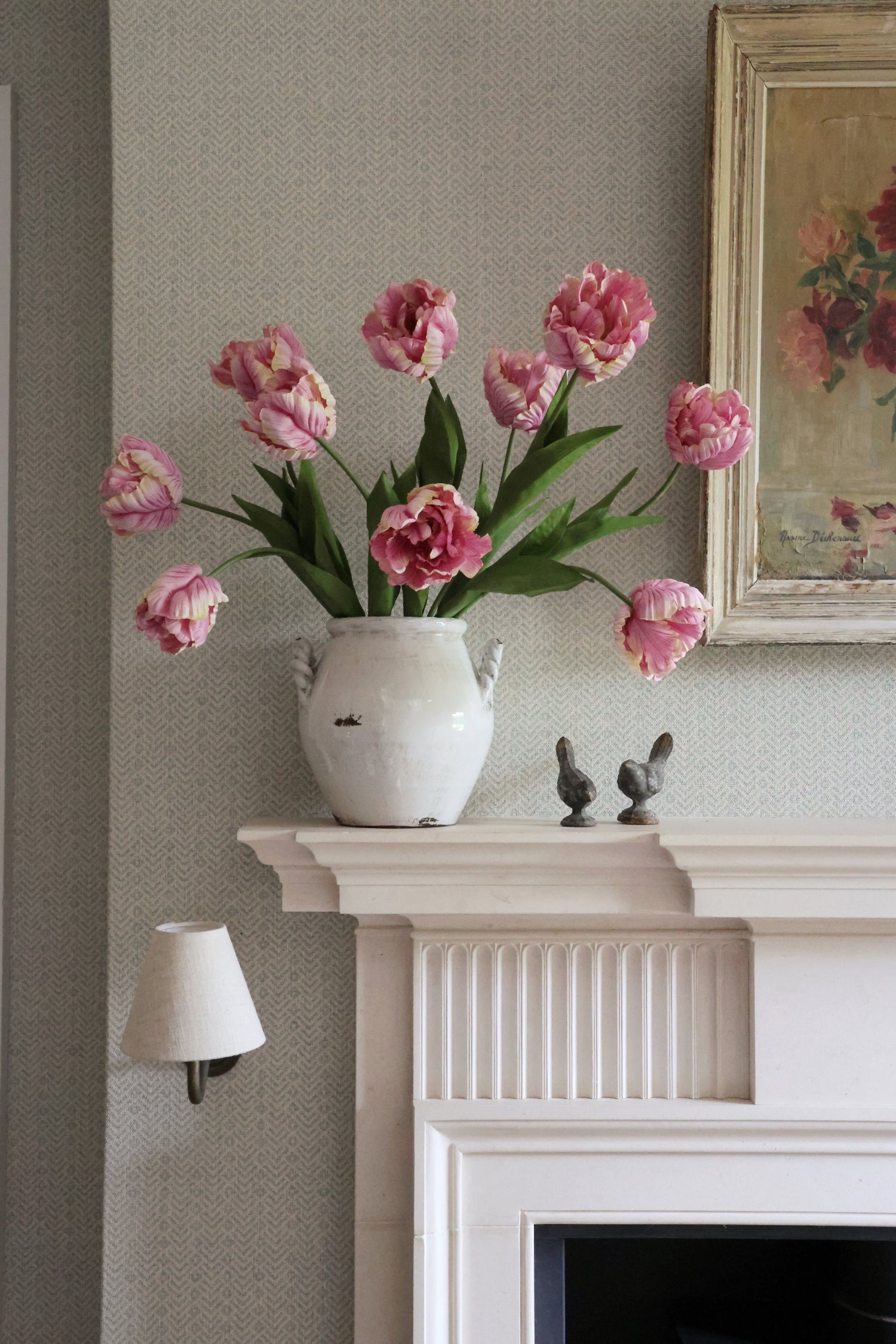 pink tulips in white vase on mantle piece