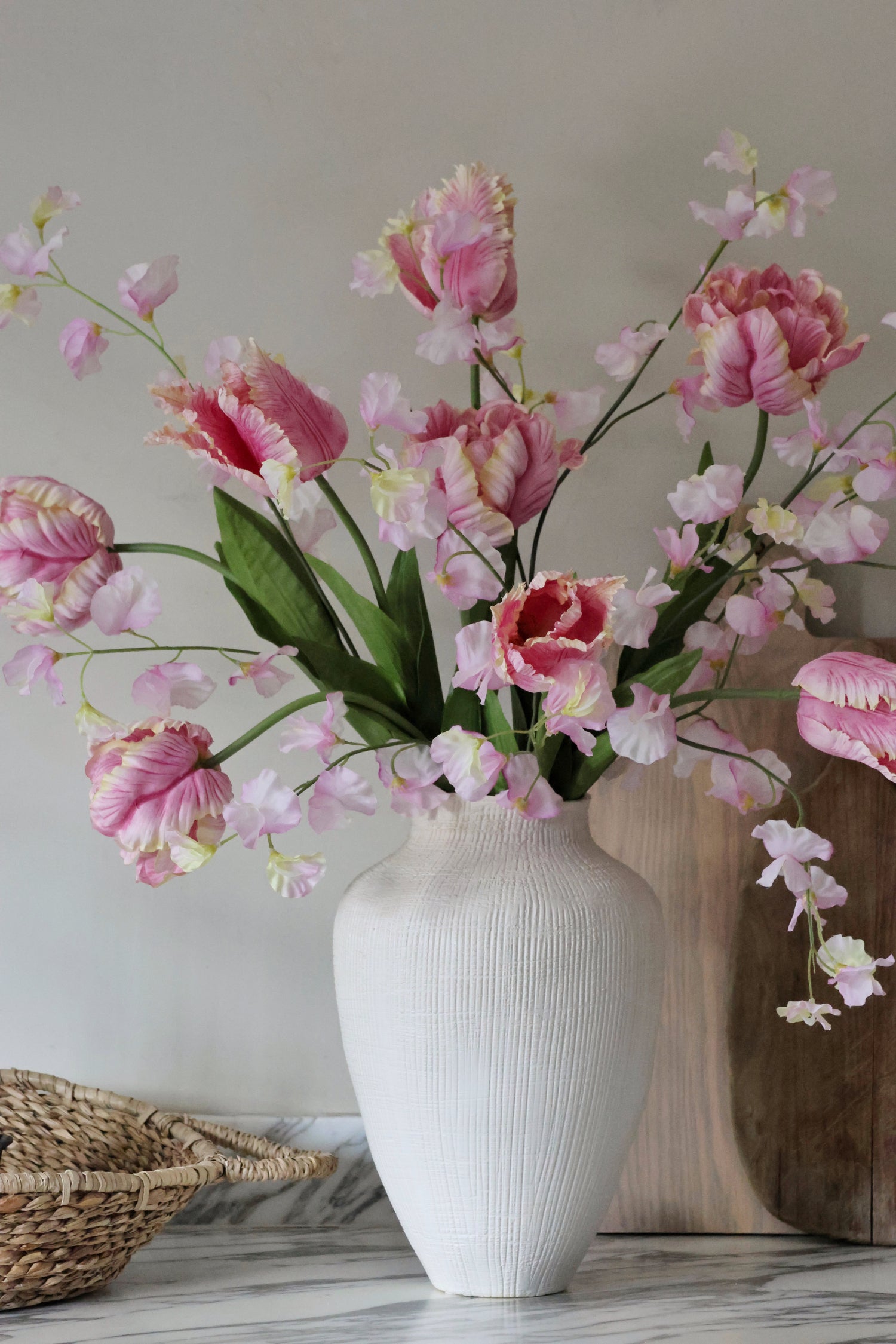 White vase with pink and white flowers on a neutral background