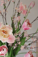 Bouquet of pink and white flowers with green leaves on a light gray background