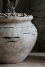 close up of distressed stone effect barrow planter 