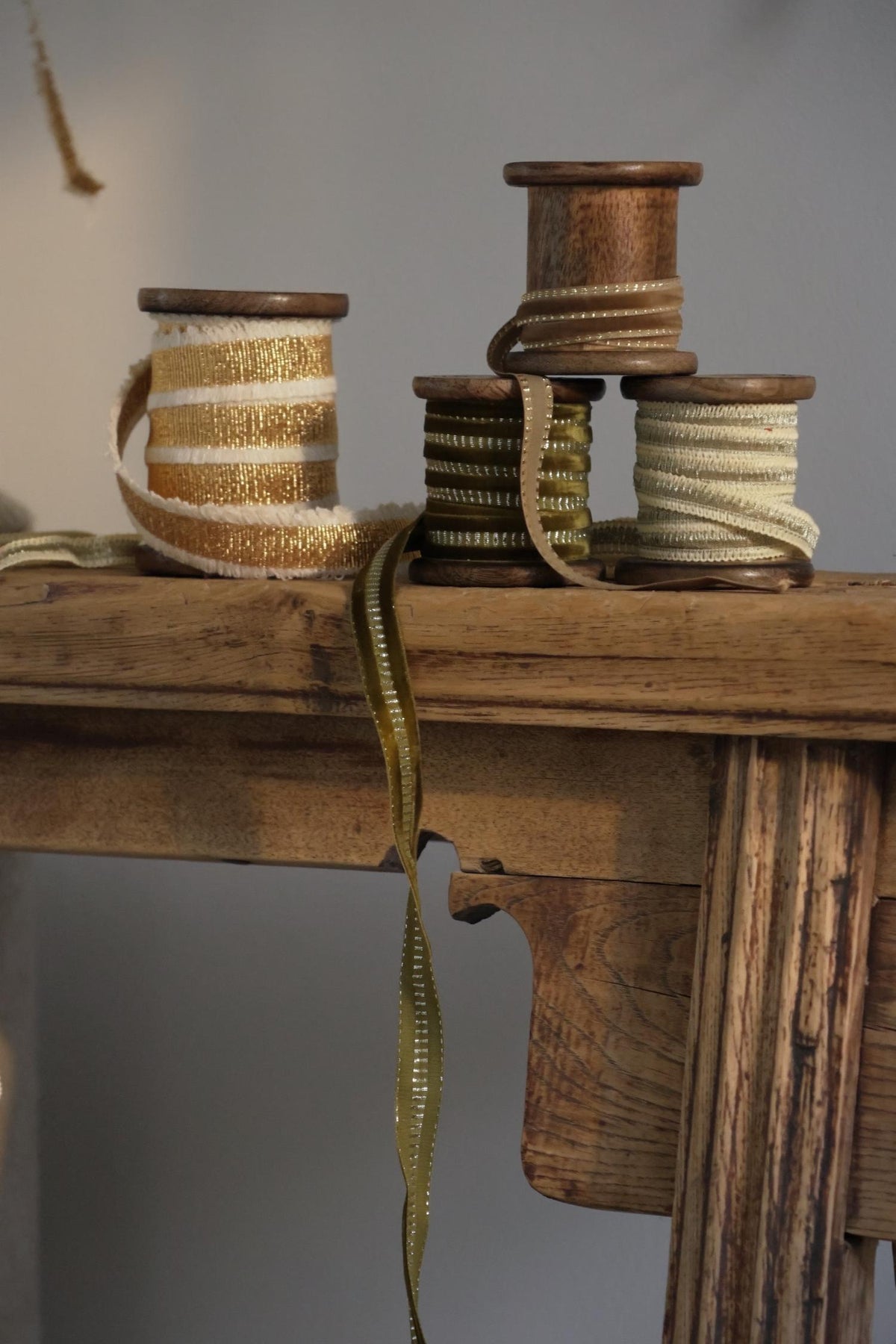 velvet ribbons in gold and olive green on a wooden bench 