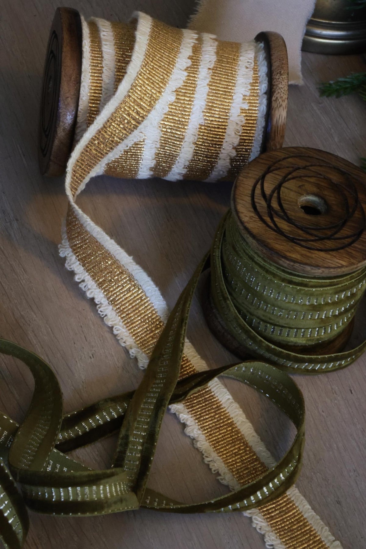 gold and olive green elegant ribbons on wooden spool 