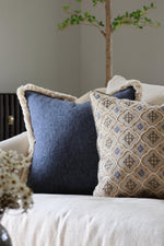 Decorative blue cushions on a sofa with a neutral background