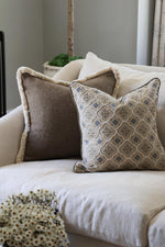 Decorative cushions on a beige sofa with a neutral background