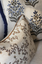 Close-up of patterned brown and blue cushions with floral designs on a neutral background